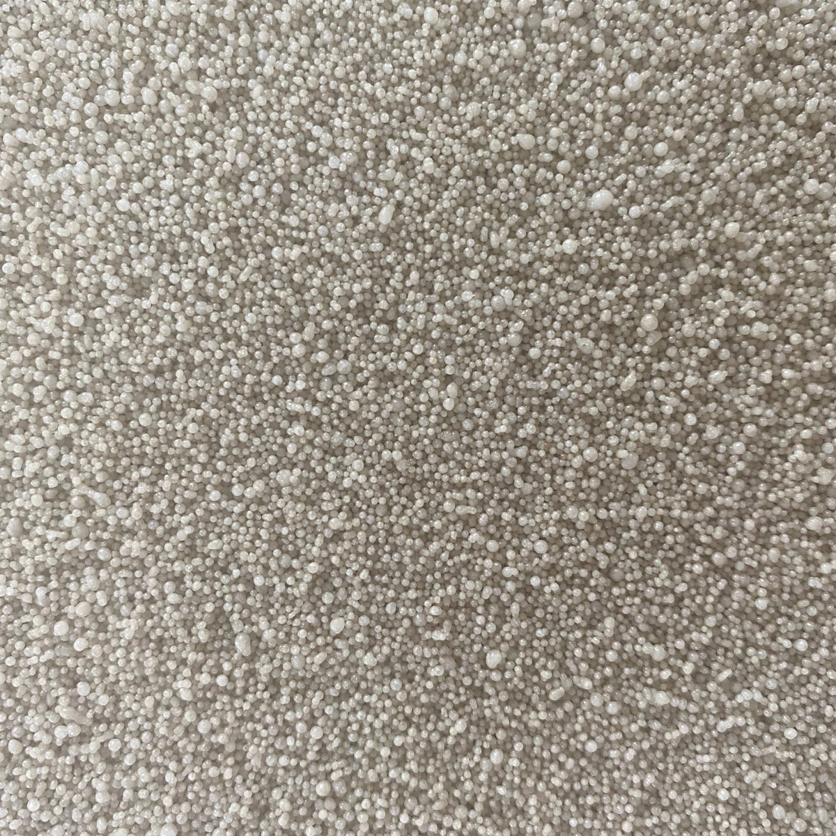A close-up texture shot of a dense, short-pile loop pile carpet in a light beige or off-white color.