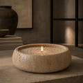 Ceramic bowl with a candle on a textured surface