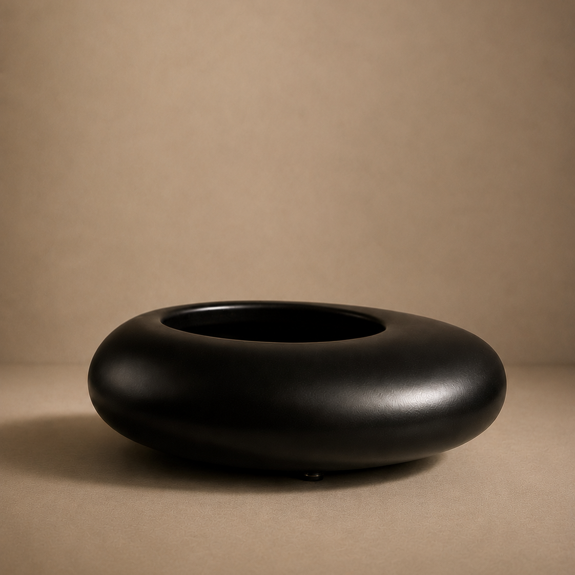 Black ceramic bowl on a beige background